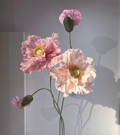 Giant paper flowers towering elegantly on stands, adding a majestic touch to any setting
