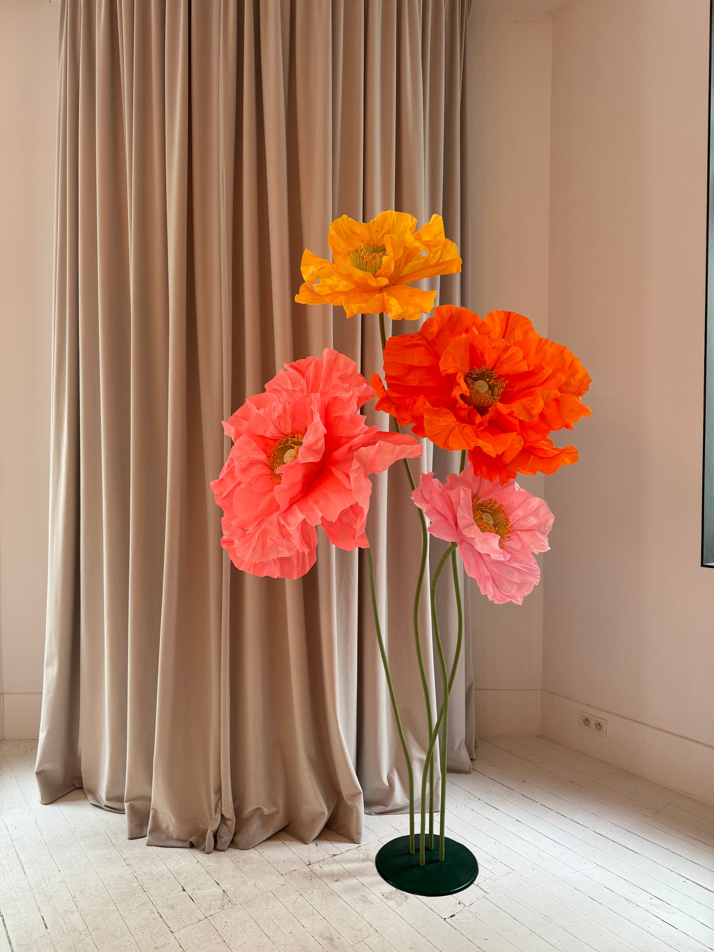 Free-standing giant paper flowers in yellow and orange for garden events