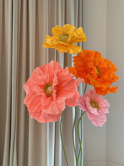 Giant paper flowers in yellow and orange tones for event decor