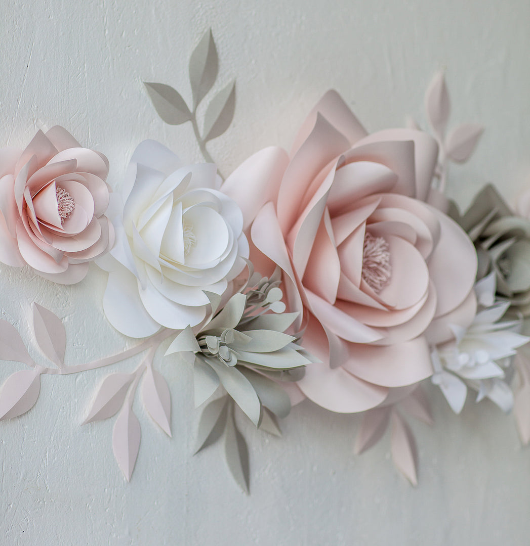 Whimsical Beauty: Blush and Light Grey Paper Flowers Adorning Nursery Walls